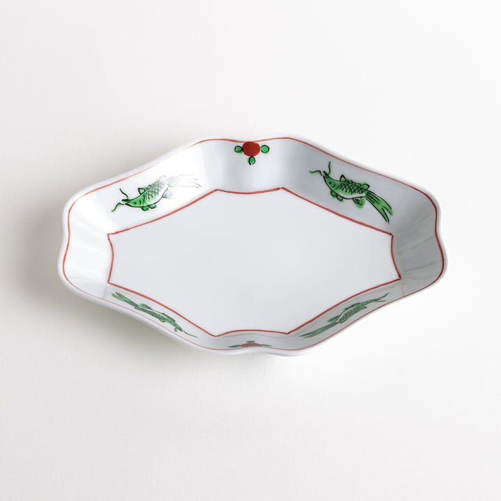 An irregularly shaped porcelain dish featuring hand-painted designs of fish and plants.