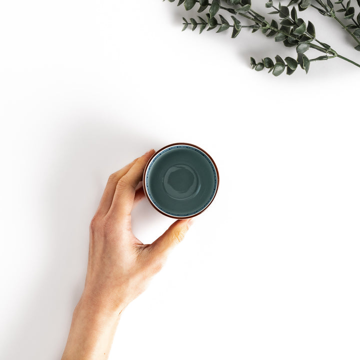 Top view of a teacup with a teal interior, showcasing its smooth glaze and a comfortable grip for a refined tea-drinking experience.