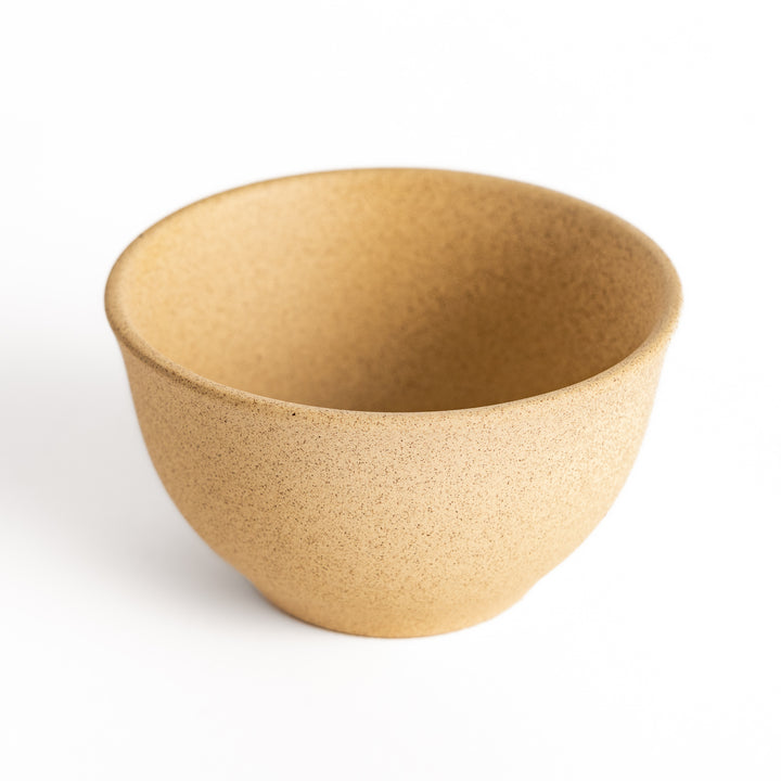 Close-up of the beige teacup, focusing on its finely textured surface and gently rounded edges.