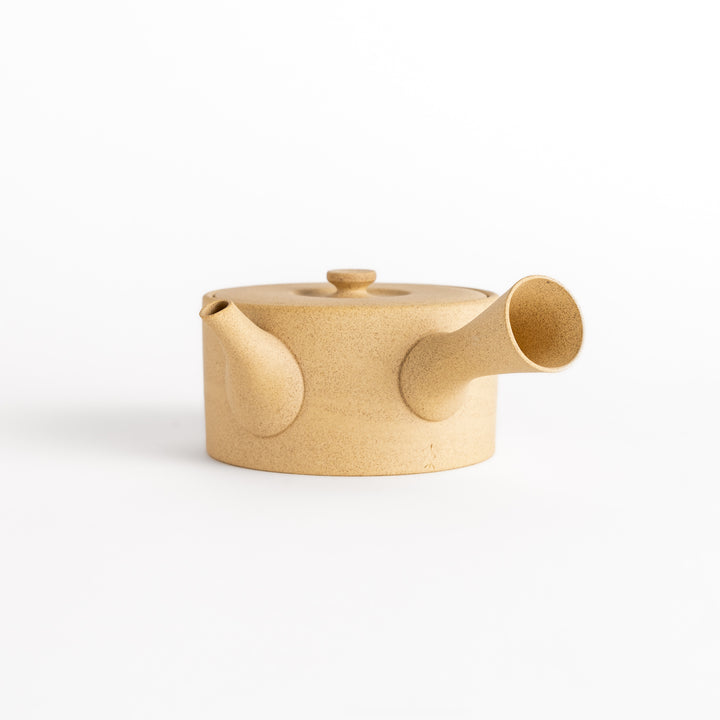 Minimalist beige teapot with a horizontal spout and handle design, crafted from textured ceramic, perfect for contemporary tea service.