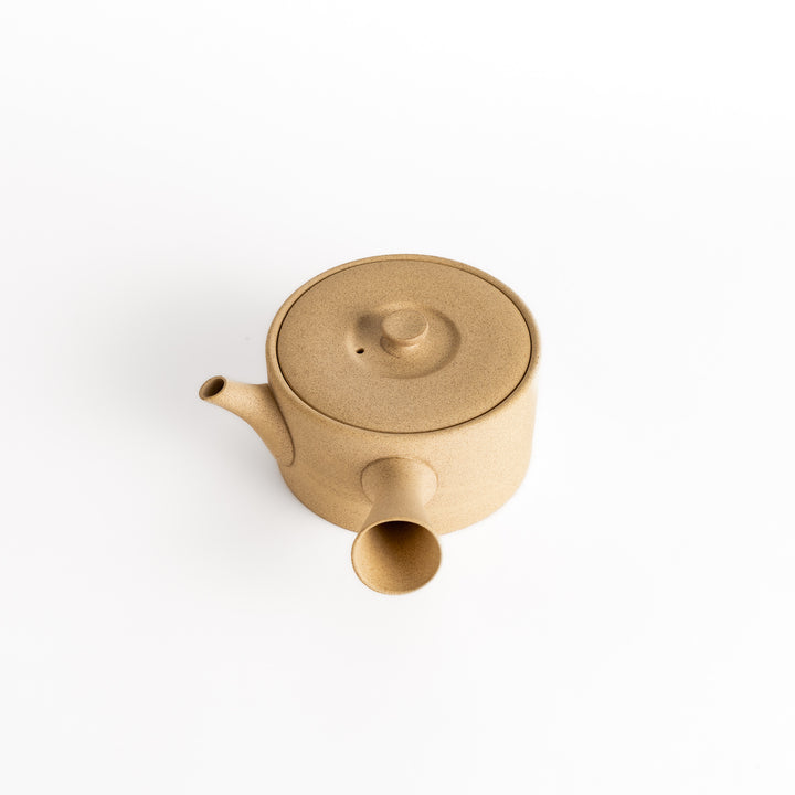 Slightly angled view of the beige teapot, focusing on its elegant proportions and horizontal spout and handle.