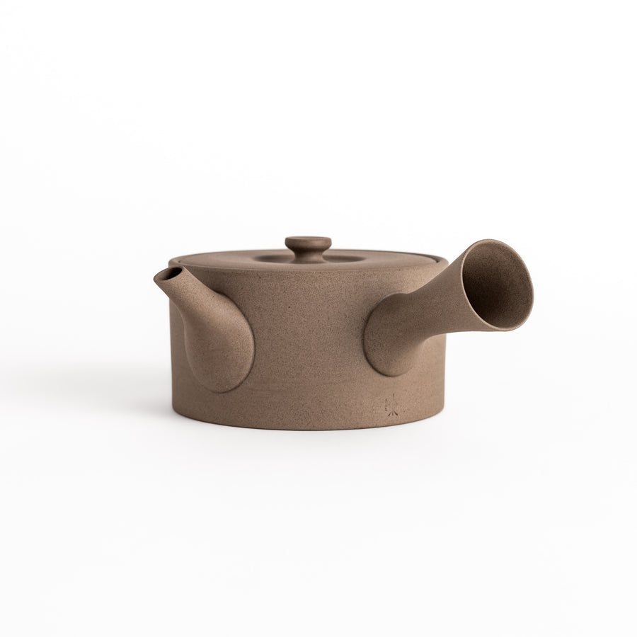 Minimalist gray teapot with a horizontal spout and handle, crafted from textured ceramic, perfect for a refined tea experience.