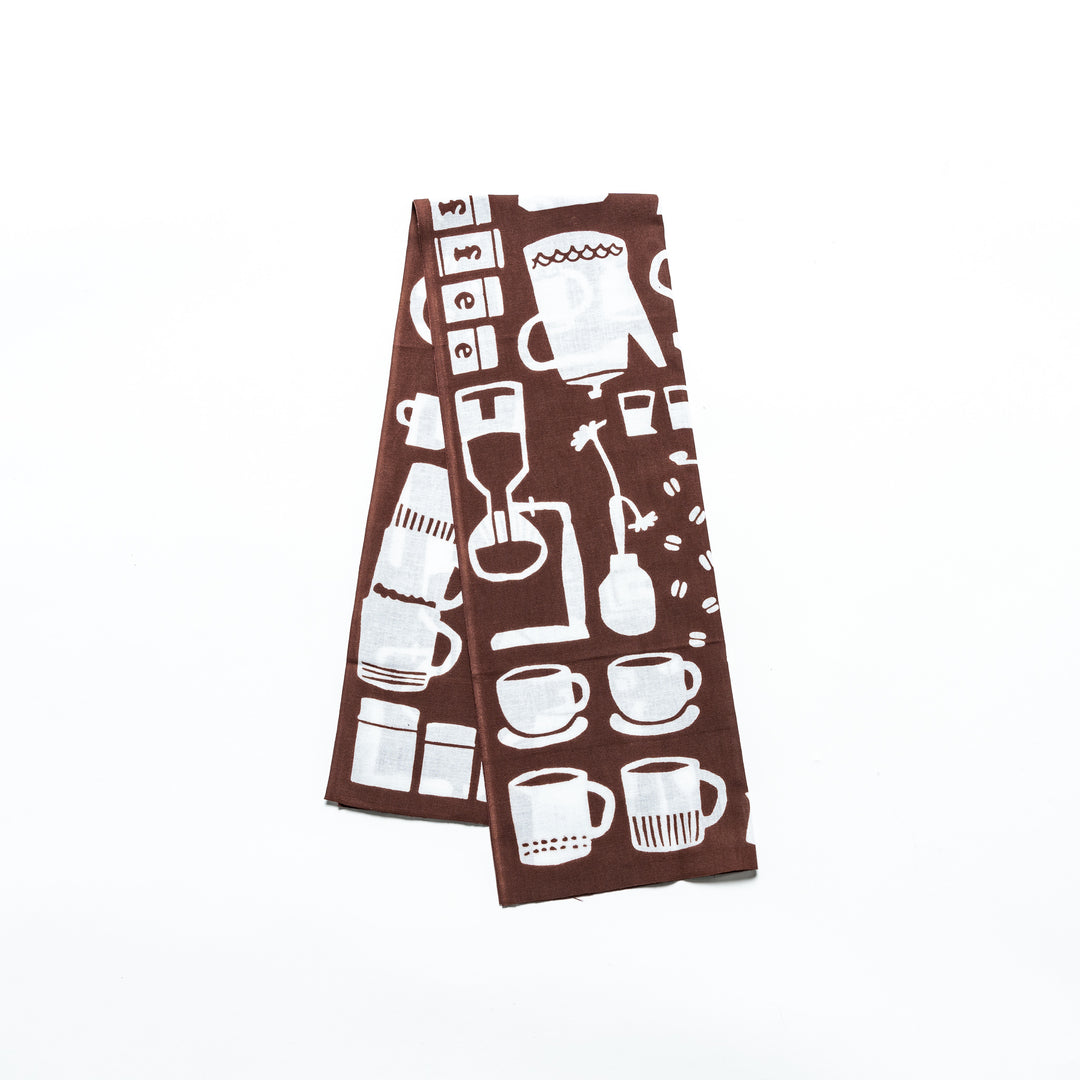 A brown tenugui hand towel featuring white illustrations of coffee pots, cups, and barista tools.