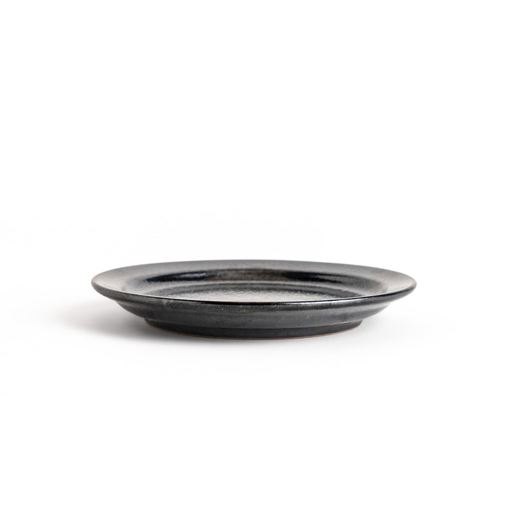 Black ceramic dessert plate with a glossy finish and minimalist design, perfect for serving small treats or appetizers elegantly.