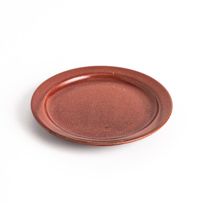 Red ceramic dessert plate with a glossy finish and minimalist design, perfect for serving small treats or appetizers elegantly.