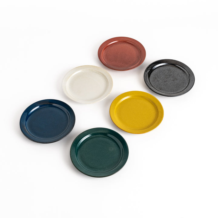 Six colorful dessert plates in black, white, red, blue, green, and yellow, each featuring a glossy finish and minimalist design.