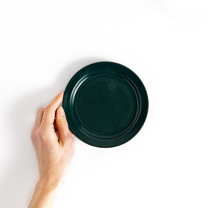 Hand-held green ceramic dessert plate showcasing its sleek glossy surface and compact size, ideal for everyday dining or special occasions.