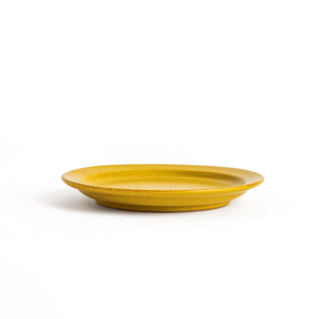 Yellow ceramic dessert plate with a glossy finish and minimalist design, perfect for serving small treats or appetizers elegantly.