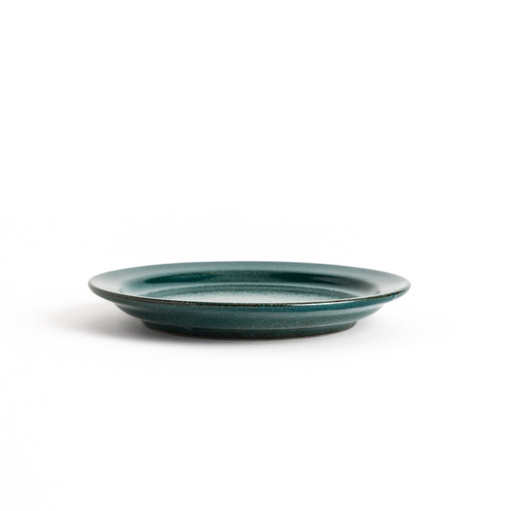 Green ceramic dessert plate with a glossy finish and minimalist design, perfect for serving small treats or appetizers elegantly.