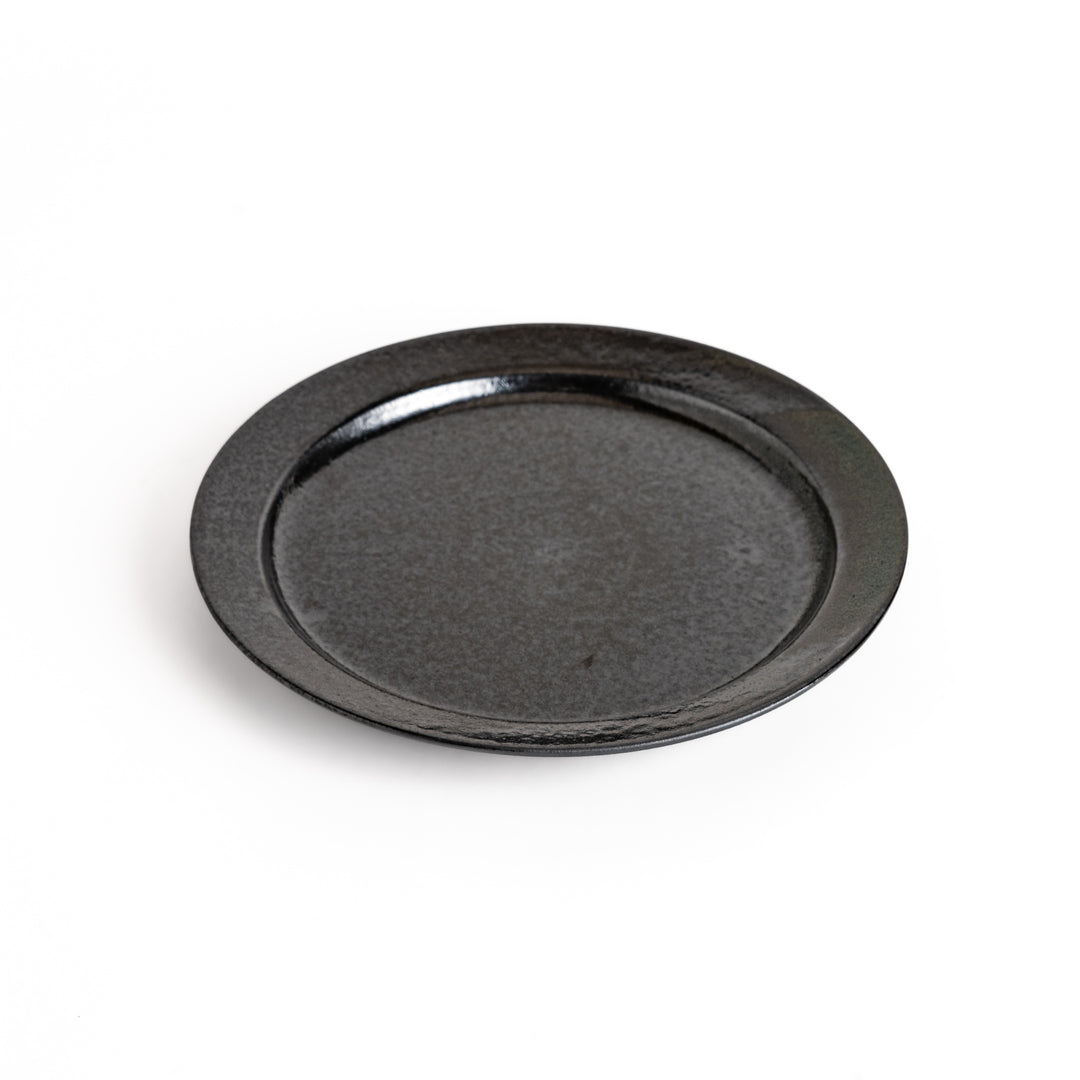 Black ceramic dinner plate with a glossy finish, showing its smooth texture. Minimalist design adds elegance to any table setting.