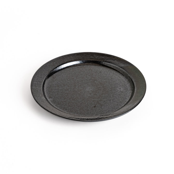 Black ceramic dinner plate with a glossy finish, showing its smooth texture. Minimalist design adds elegance to any table setting.