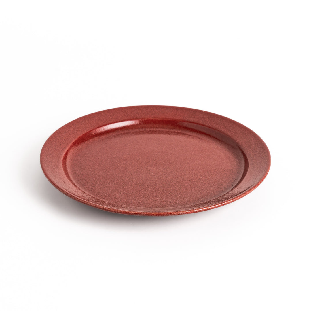 Red ceramic dinner plate with a glossy finish, providing a bold and vibrant accent to any dining arrangement.