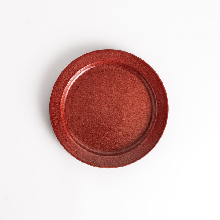 Red ceramic dinner plate with a glossy finish, providing a bold and vibrant accent to any dining arrangement.