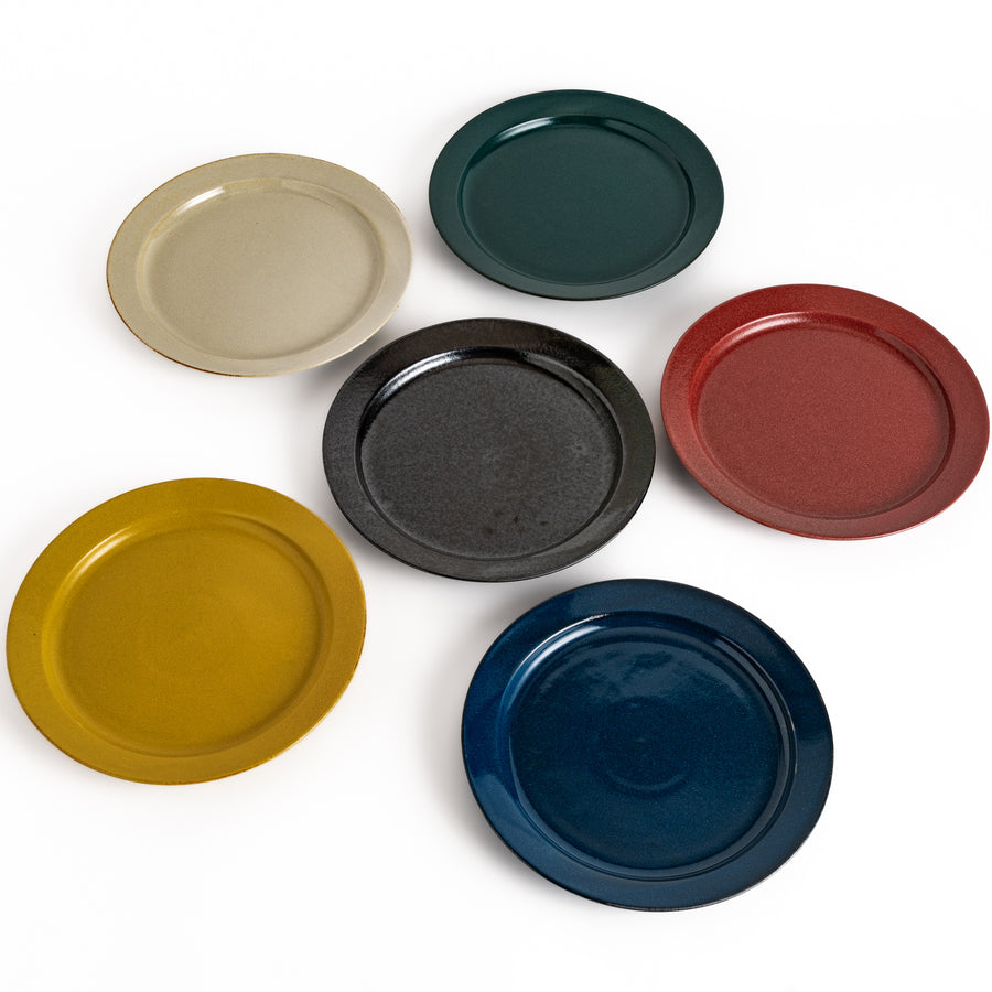 Six colorful dinner plates in black, white, red, blue, green, and yellow, featuring a glossy finish and minimalist design, perfect for dining.