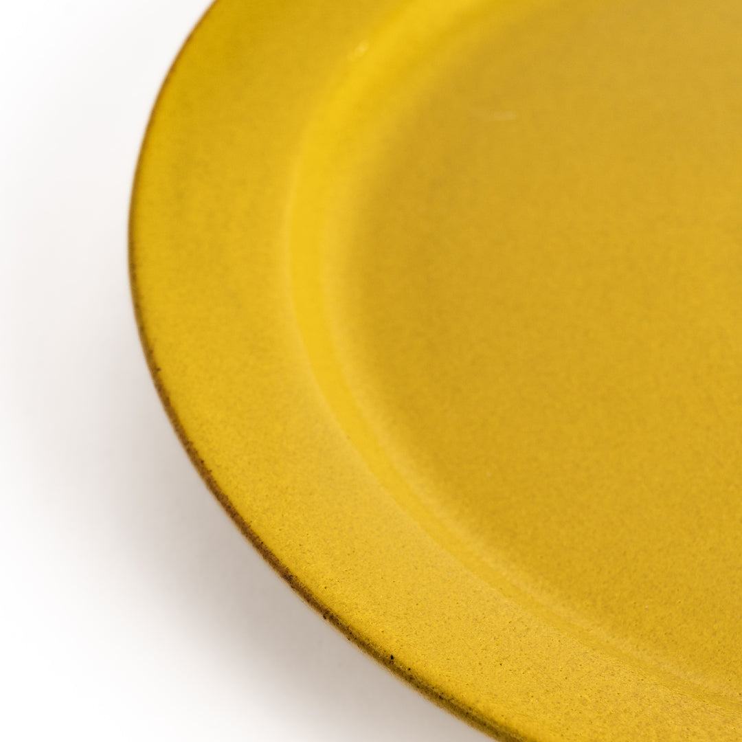 Yellow ceramic dinner plate with a glossy finish, bringing a cheerful and bright touch to any dining experience.