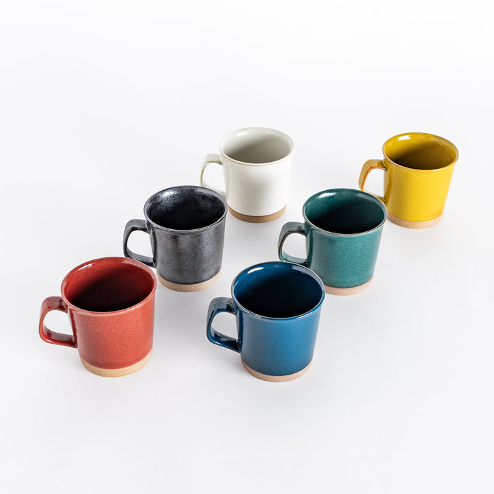 Six ceramic mugs in vibrant colors including red, black, white, yellow, green, and blue. Each features a neutral-toned base, perfect for everyday use.