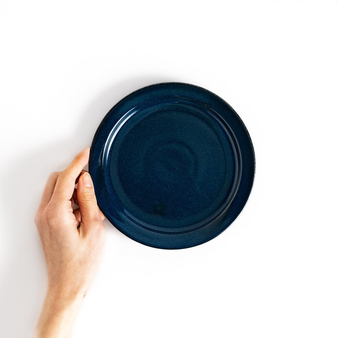 Hand holding a blue salad plate, showcasing its size and versatile design ideal for salads and sides.