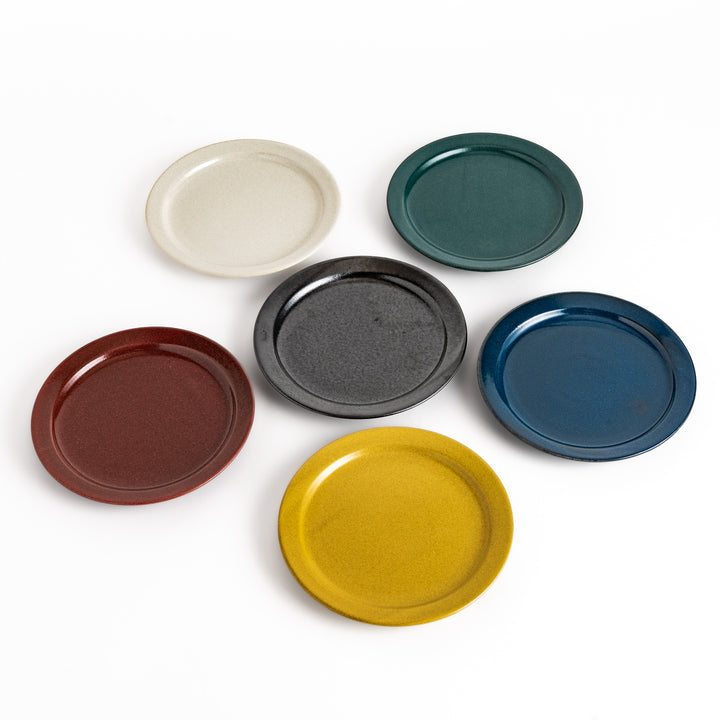 Six ceramic salad plates in black, white, red, blue, green, and yellow, with glossy finishes, showcasing vibrant and elegant designs.