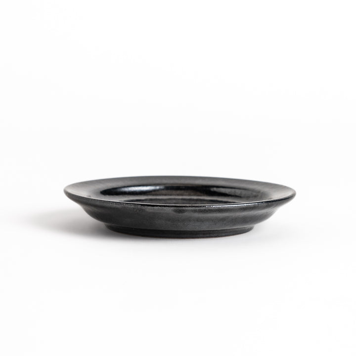 Black ceramic sauce dish with a glossy finish and a minimalist design, ideal for serving dips or condiments elegantly.