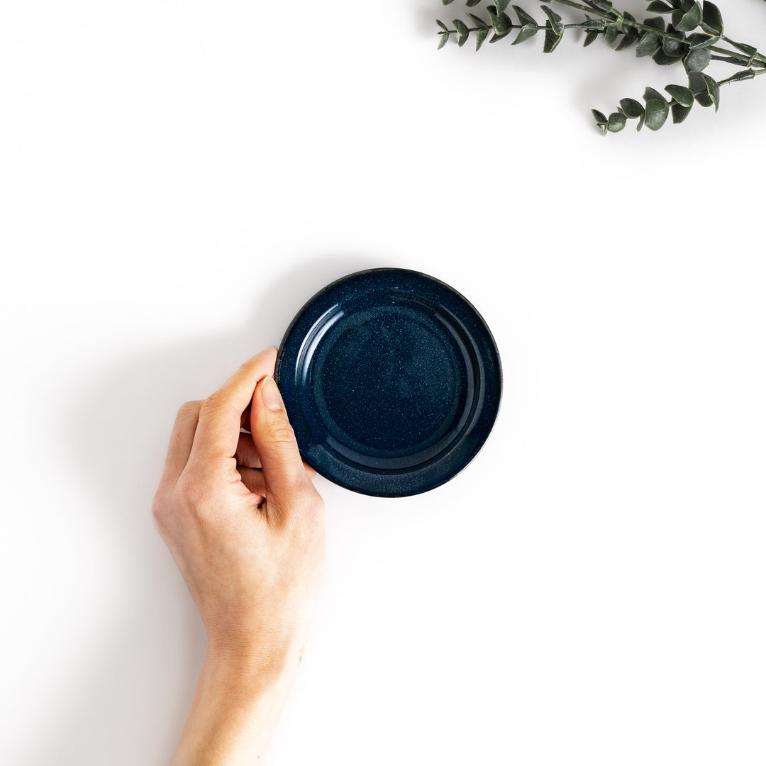 Hand-held blue ceramic sauce dish showcasing its sleek glossy surface and compact size, perfect for everyday use.