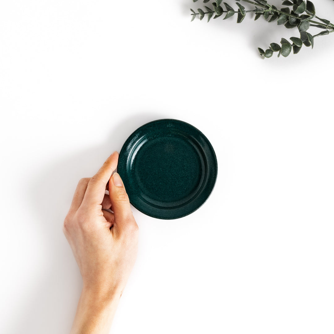 Hand-held green ceramic sauce dish showcasing its sleek glossy surface and compact size, perfect for everyday use.