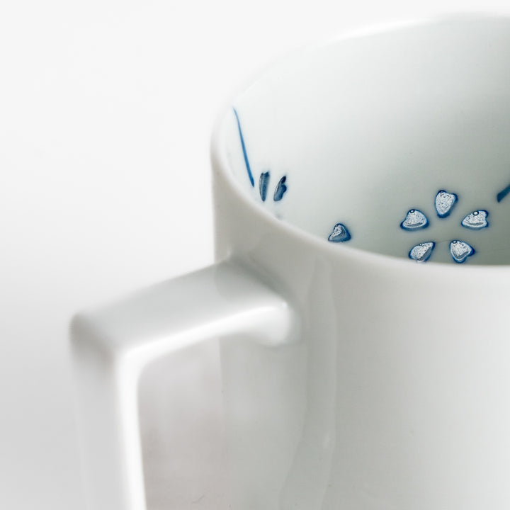 Elegant white ceramic mug with a subtle blue floral pattern, ideal for enjoying your favorite hot beverages.