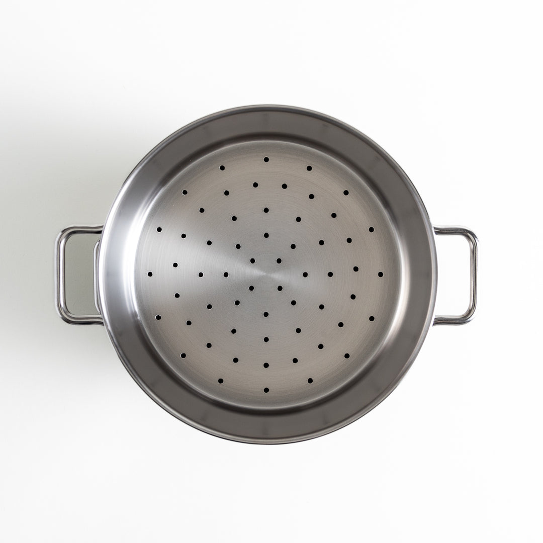 Top view of the perforated steamer section, with evenly spaced holes to ensure effective steam circulation.