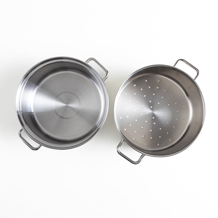 Overhead view of two parts of the stainless steel steamer, one with a perforated bottom for steaming and one with a solid base.