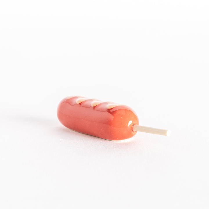 Side view of the corn dog chopsticks rest, highlighting the rounded design and stick detail.