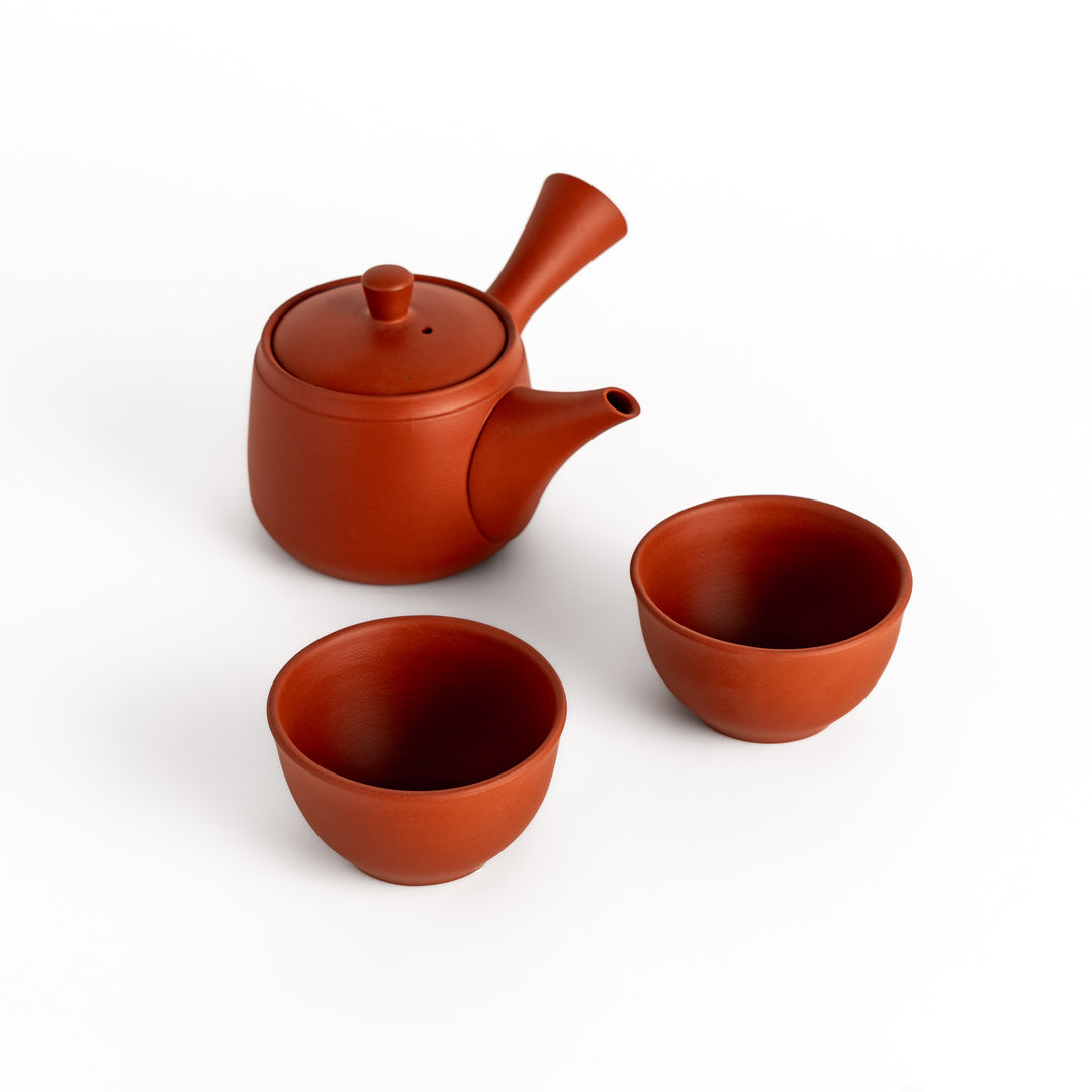 Crimson teapot paired with matching teacups, creating a harmonious set ideal for an elegant tea experience.