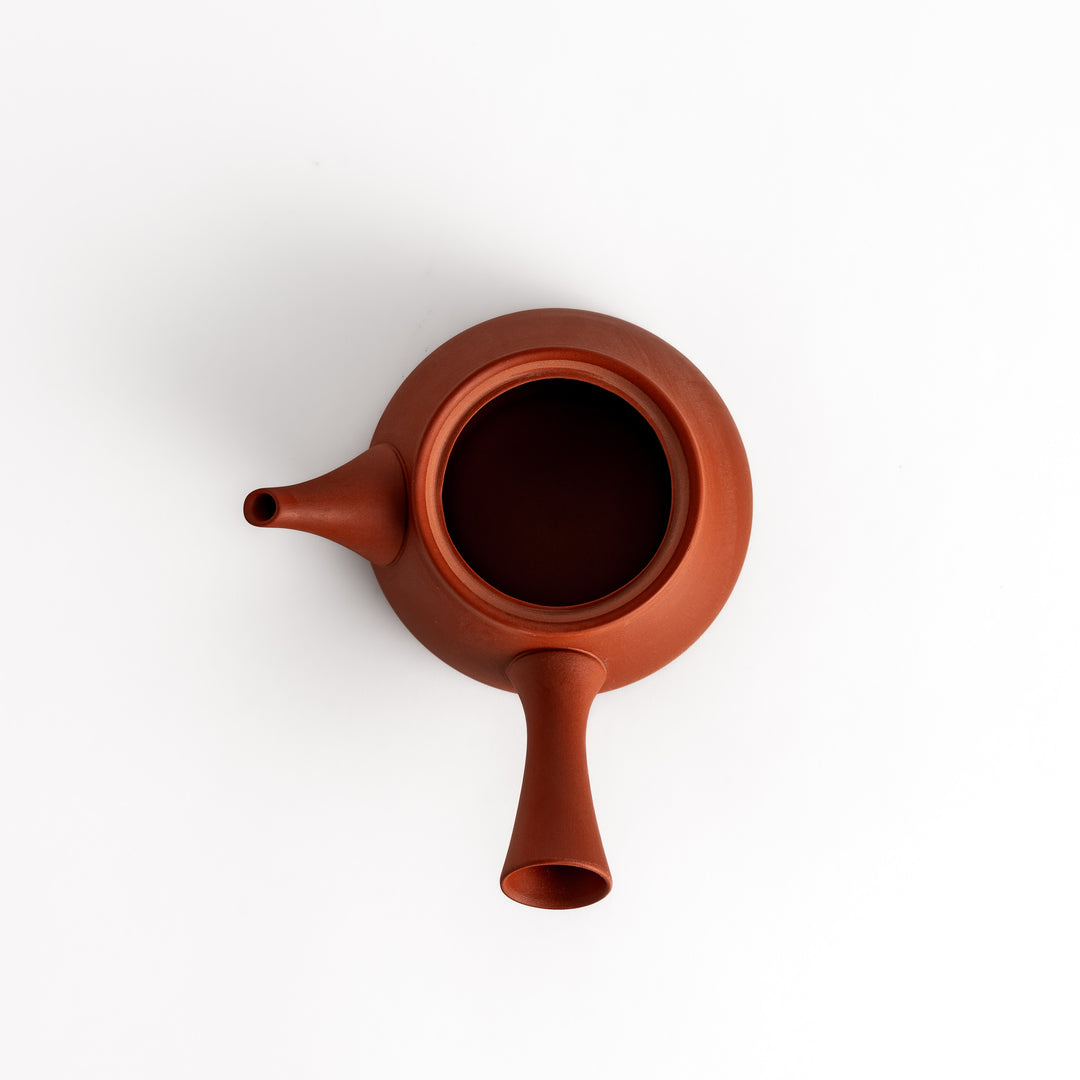 Crimson teapot with its lid removed, revealing a spacious interior and detailed craftsmanship for optimal tea brewing.