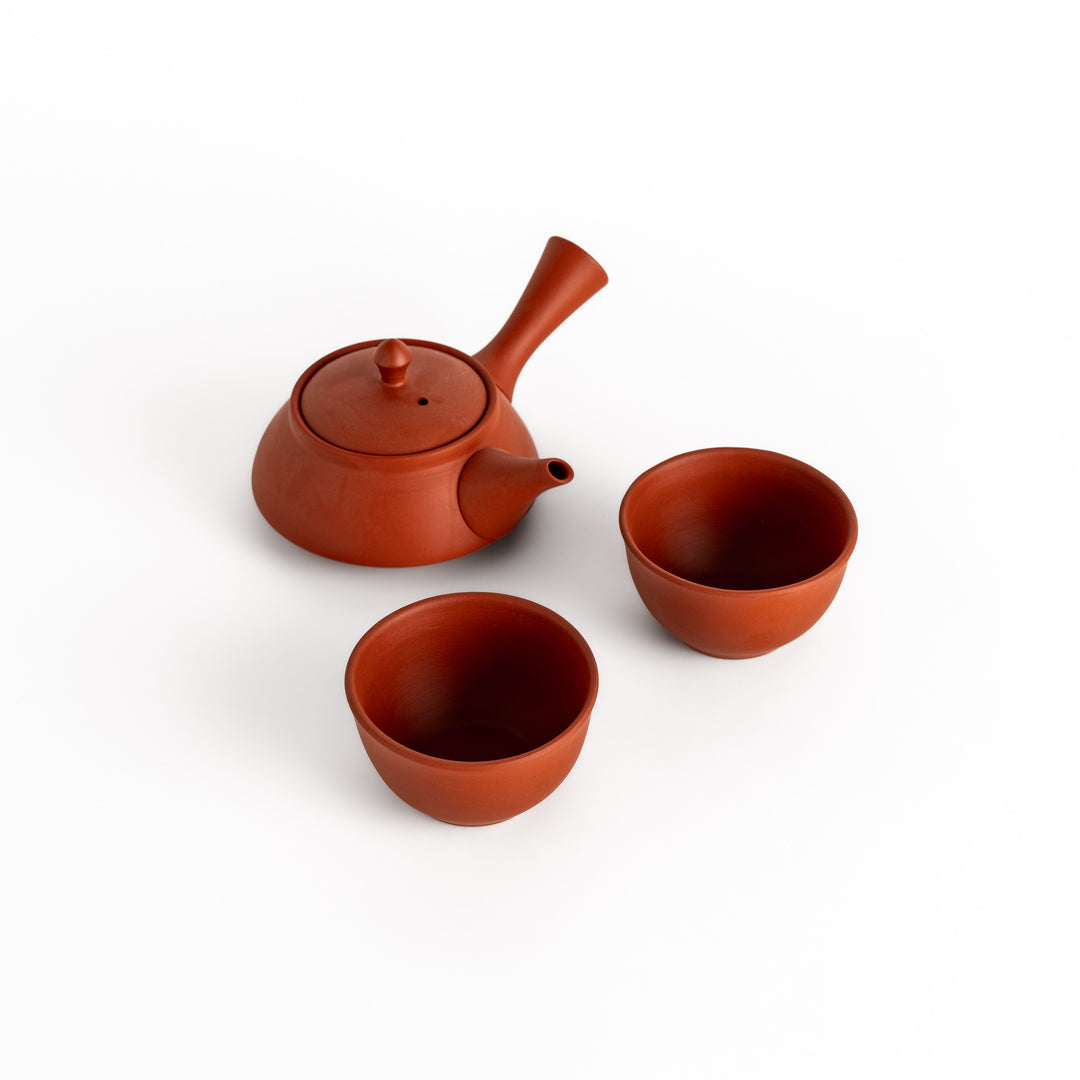 Red teacups paired with a matching teapot, creating a cohesive and stylish tea set.