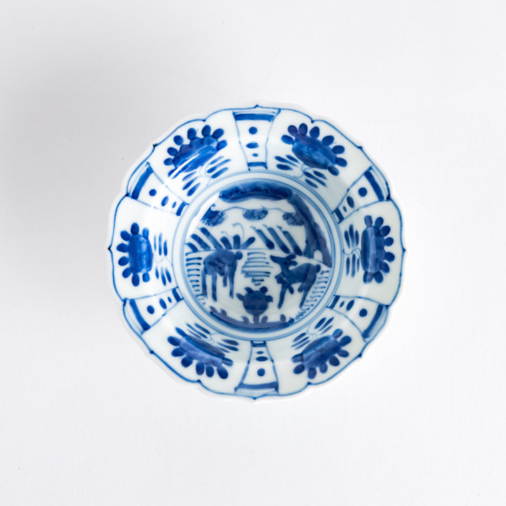 A dessert bowl with a scalloped edge, decorated in blue with pastoral scenes of deer and landscape motifs.