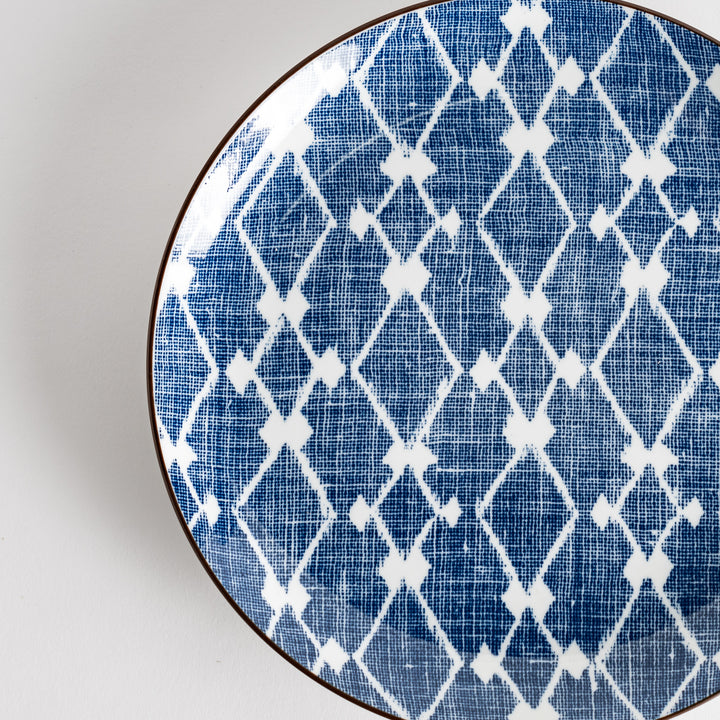 A round dinner plate displaying a blue and white lattice design, similar to traditional Japanese patterns.