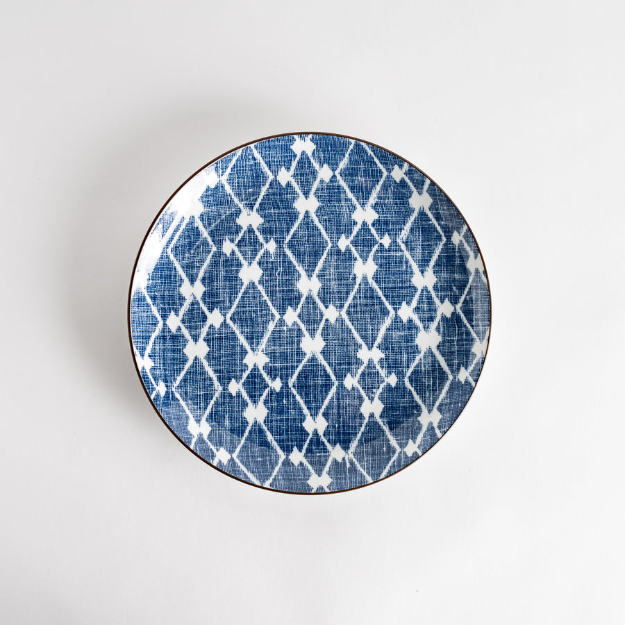 A round dinner plate displaying a blue and white lattice design, similar to traditional Japanese patterns.