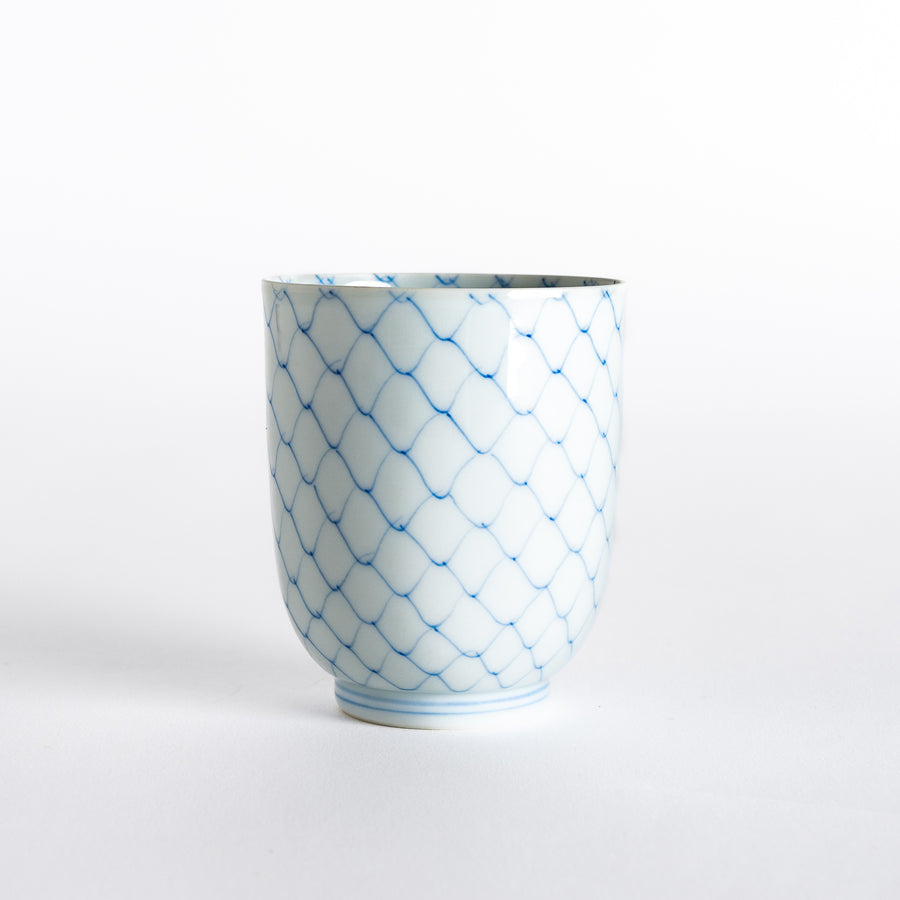 Front view of a white tea cup with an elegant blue diamond weave pattern and a slightly curved shape.