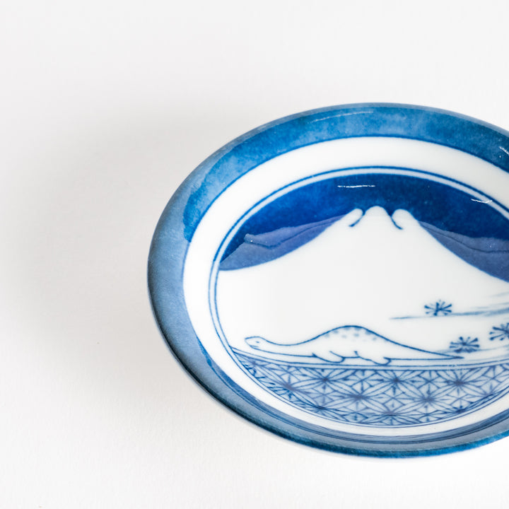 A set of four small, decorative porcelain plates in a gift box, each plate featuring a different dinosaur design in blue and red.