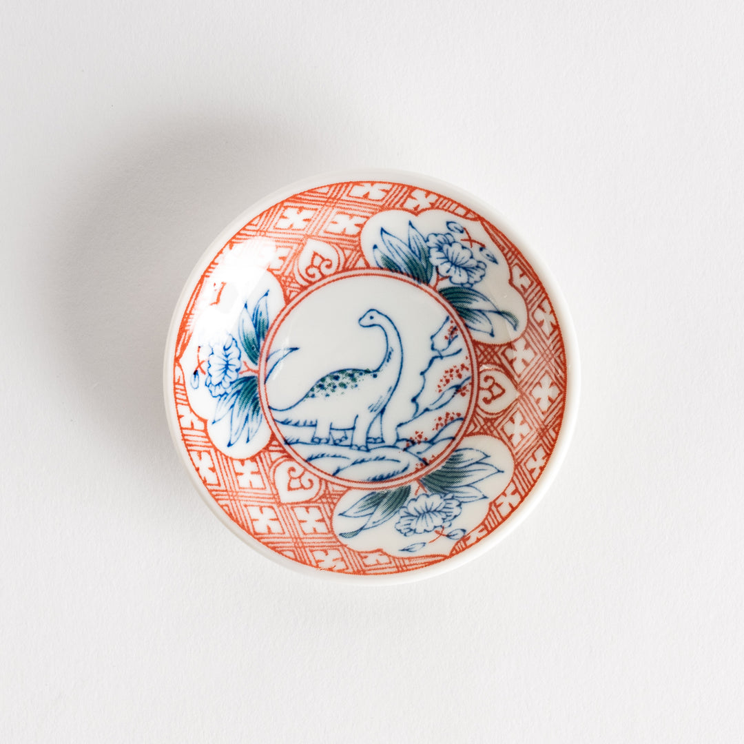 A set of four small, decorative porcelain plates in a gift box, each plate featuring a different dinosaur design in blue and red.