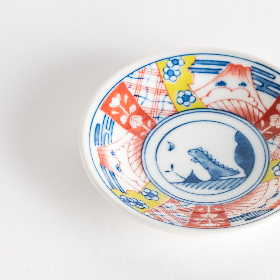 A set of four small, decorative porcelain plates in a gift box, each plate featuring a different dinosaur design in blue and red.