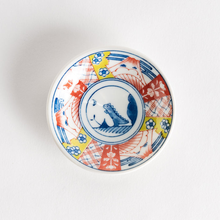 A set of four small, decorative porcelain plates in a gift box, each plate featuring a different dinosaur design in blue and red.