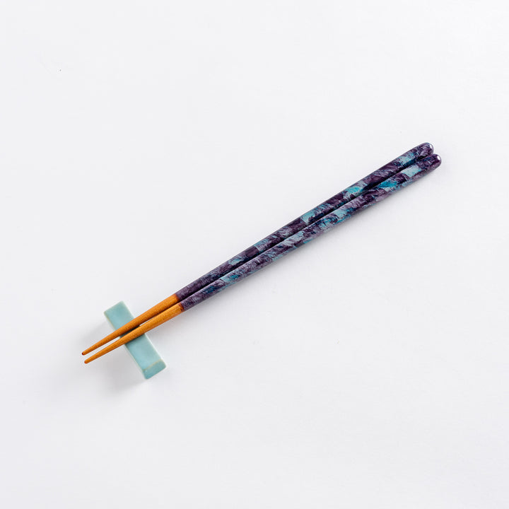 Close-up of the textured upper part of the dark blue chopsticks, showing intricate patterns.