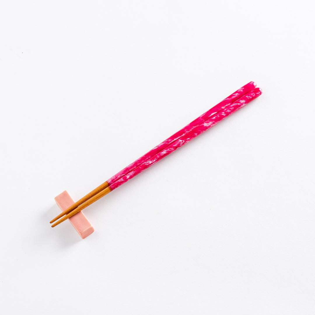 Close-up of the textured upper part of the pink chopsticks, showing intricate patterns.