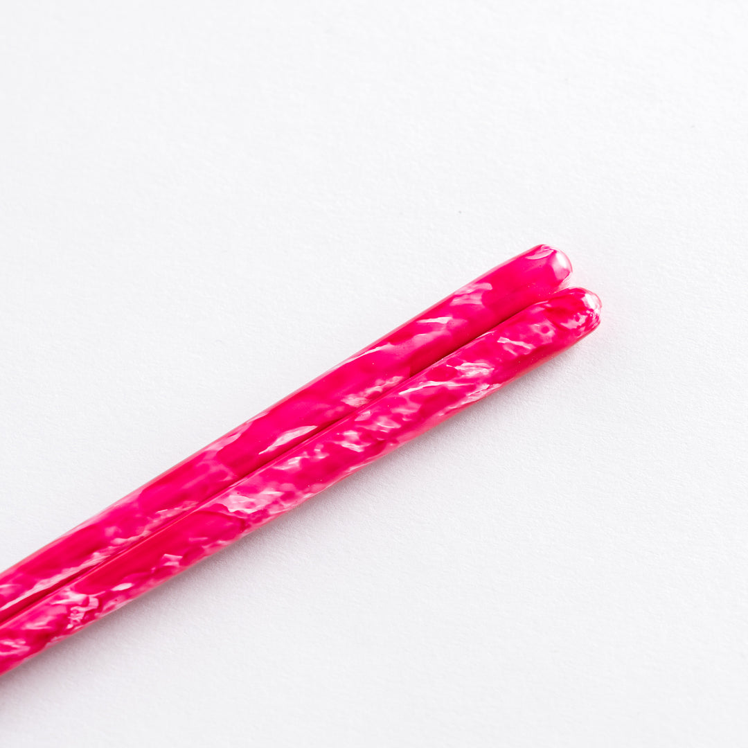 Dark blue chopsticks with a wisteria-inspired texture, placed on a blue ceramic rest.