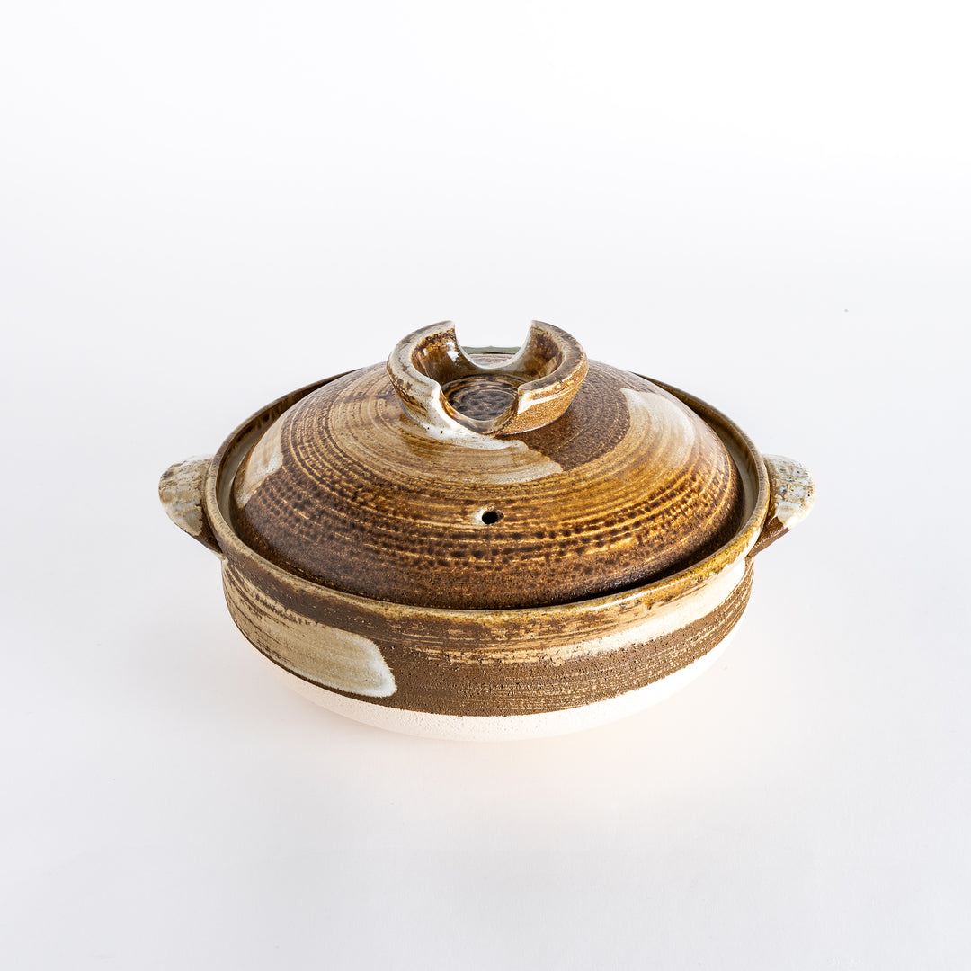 Donabe with a rustic brown glaze and earthy white accents, featuring a textured lid and two handles.