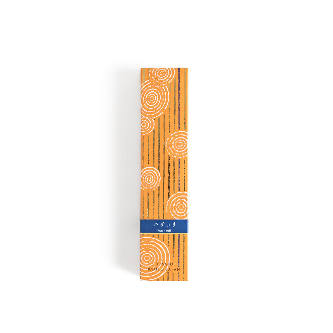 Earthy Patchouli Incense in a light wooden box with warm brown sticks, elegantly packaged in an orange design featuring white circular patterns, evoking a rich and grounding aroma.