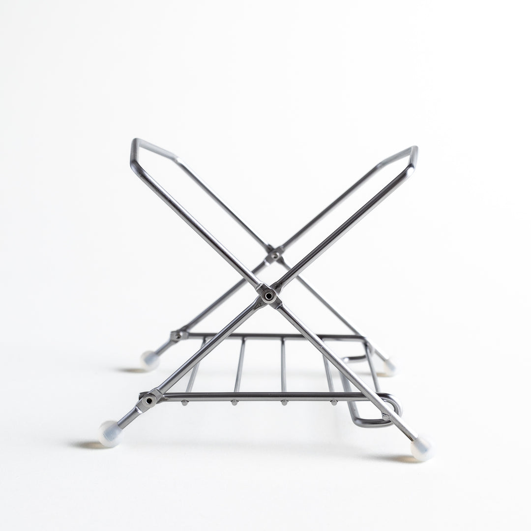 Side view of the compost holder frame, showing its cross-stand design with durable joints and rubber feet.