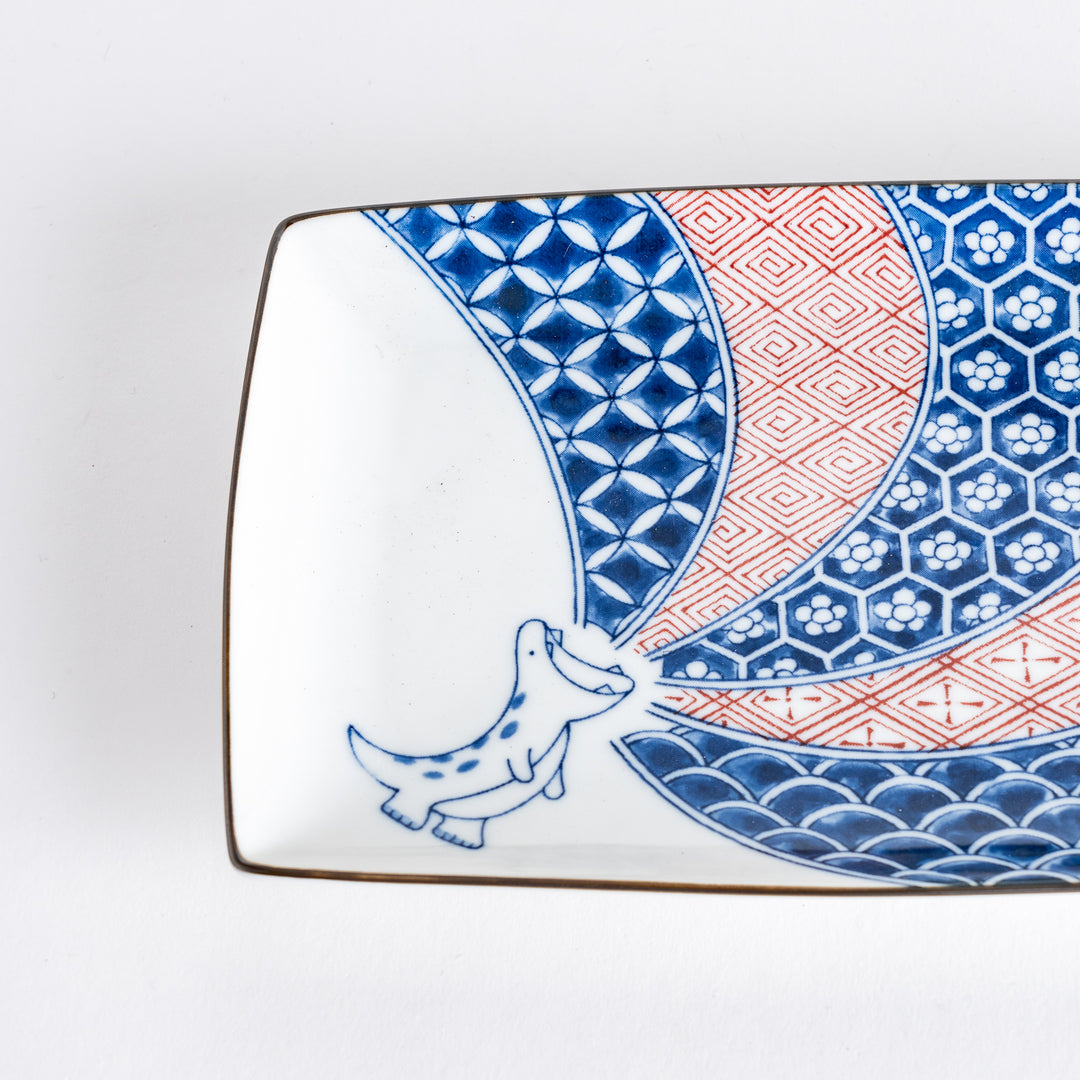 Close-up view of the dinosaur illustration on the rectangular dessert plate, highlighting the details of the patterns and colors.