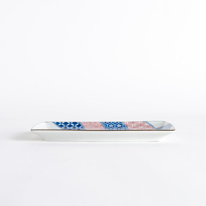 Side view of the rectangular dessert plate, showcasing the unique shape and colorful design with a dinosaur motif.