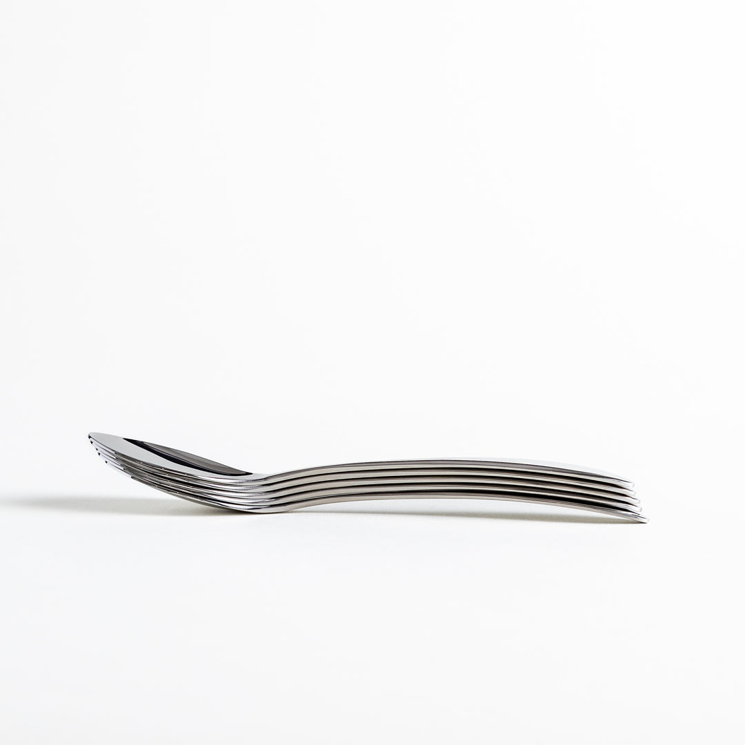 A stack of stainless steel spoons placed at an angle, showcasing their smooth, curved handles.