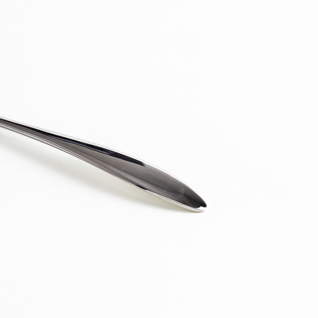 Close-up of a stainless steel spoon's handle, highlighting its sleek, smooth design.